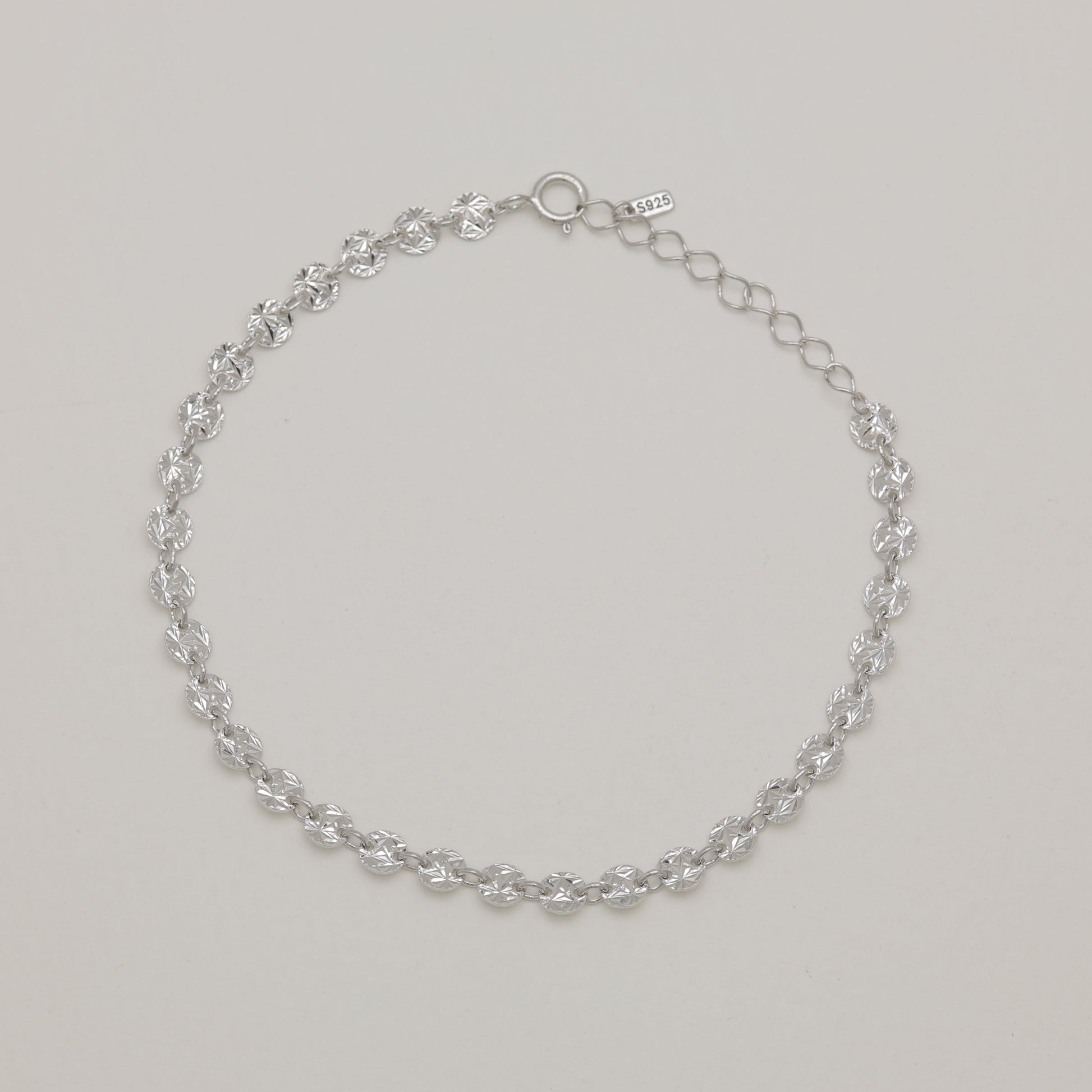 Silver chain bracelet on a light gray background