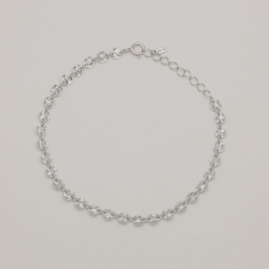 Silver chain bracelet on a light gray background