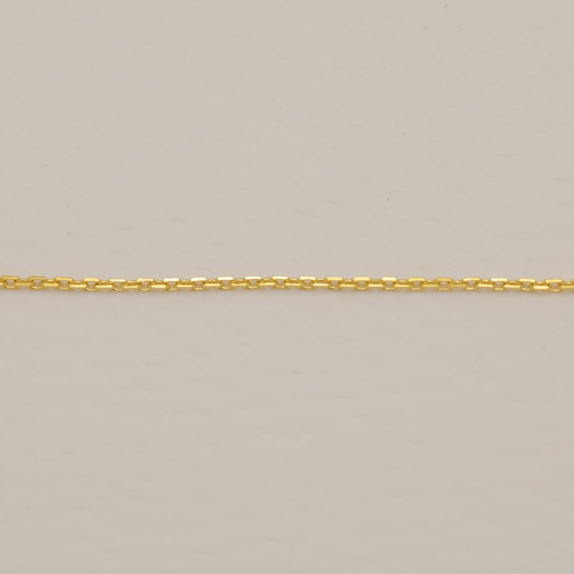 Gold chain on a beige background