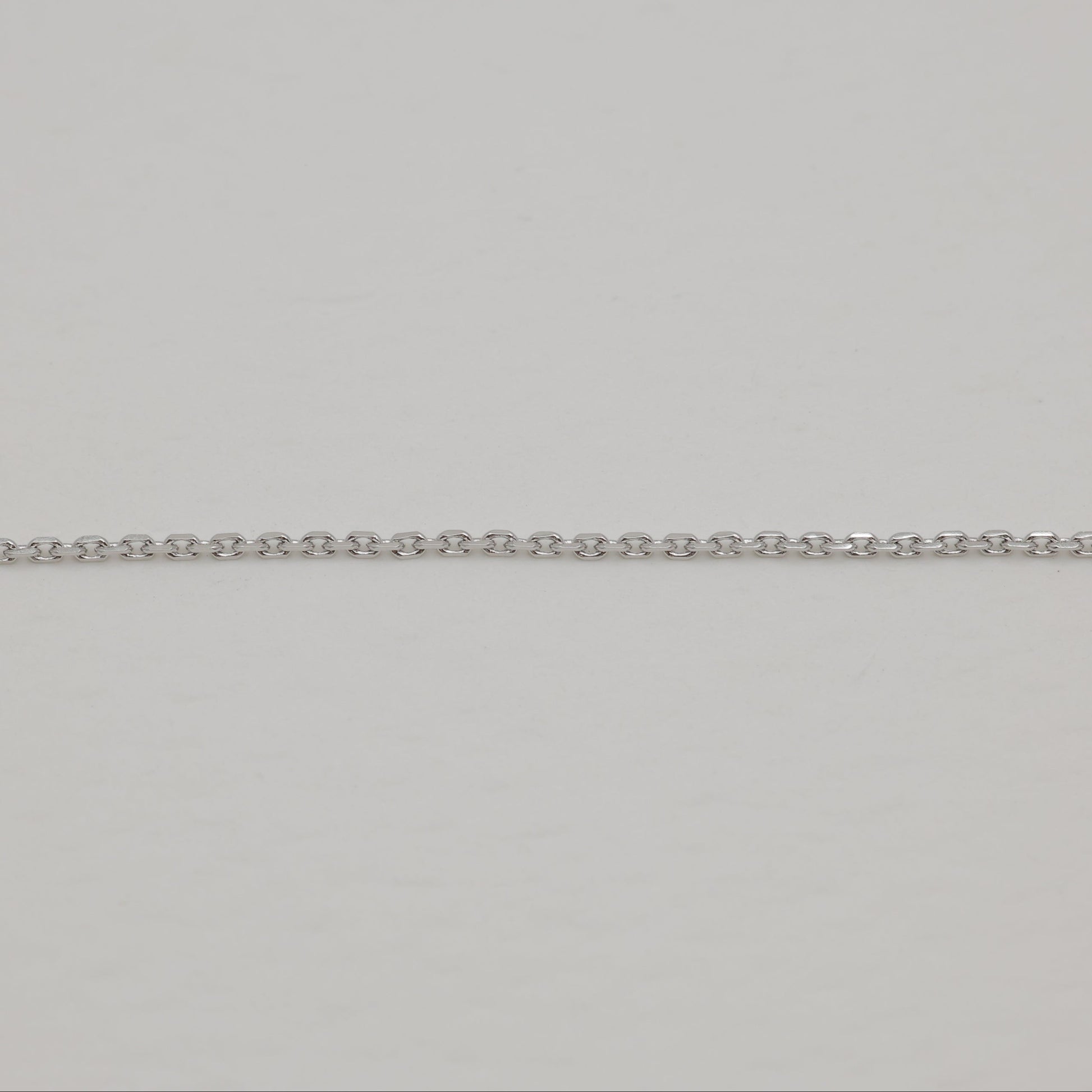 Close-up of a silver chain on a light gray background