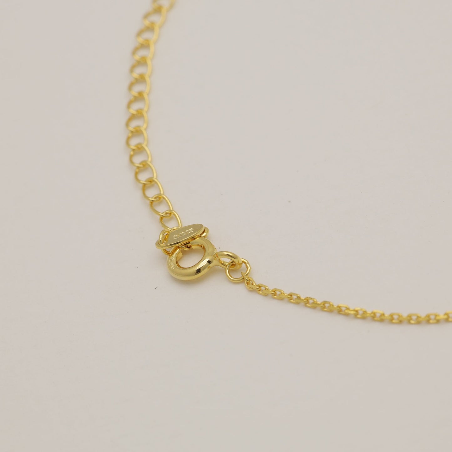 Gold bracelet on a light beige background