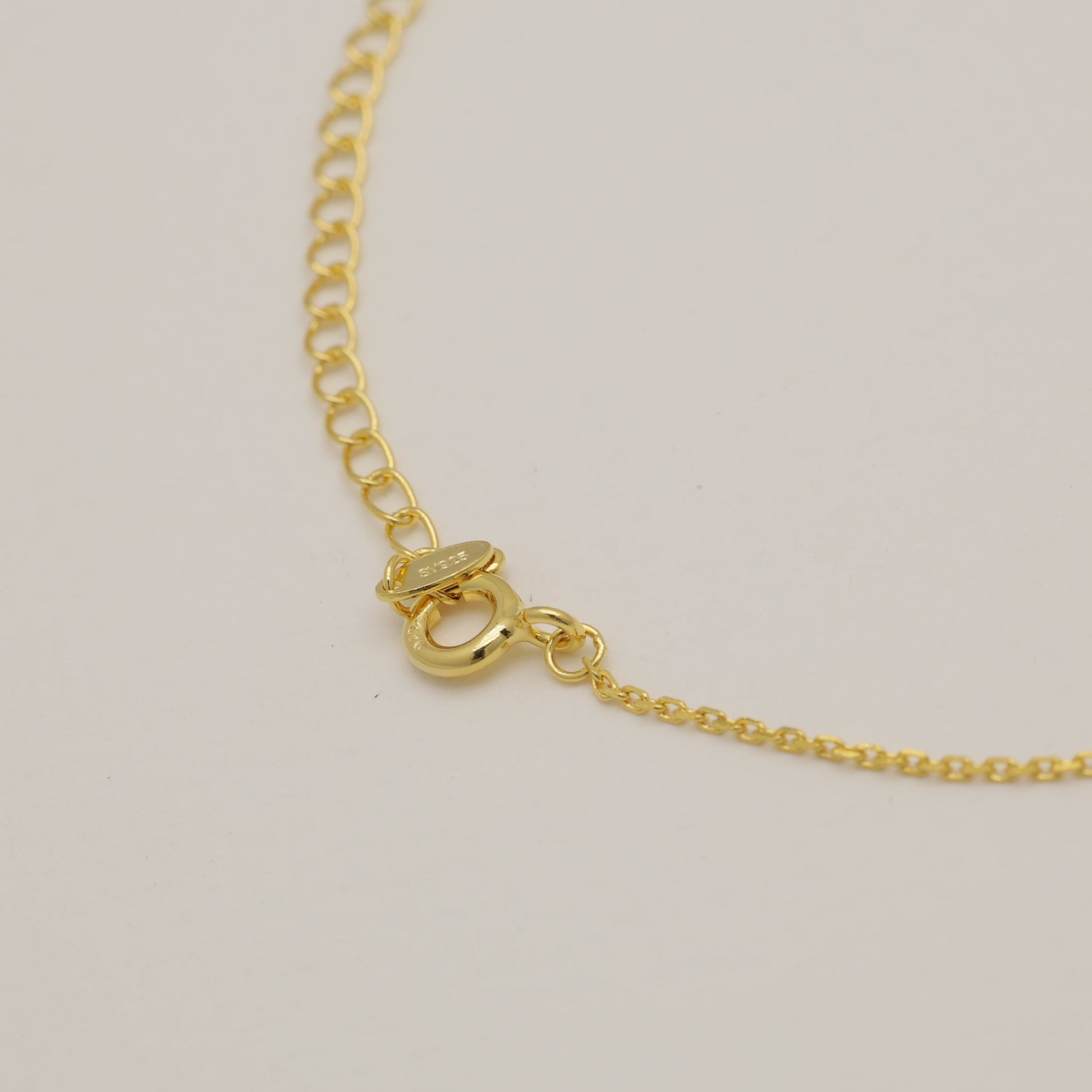 Gold bracelet on a light beige background