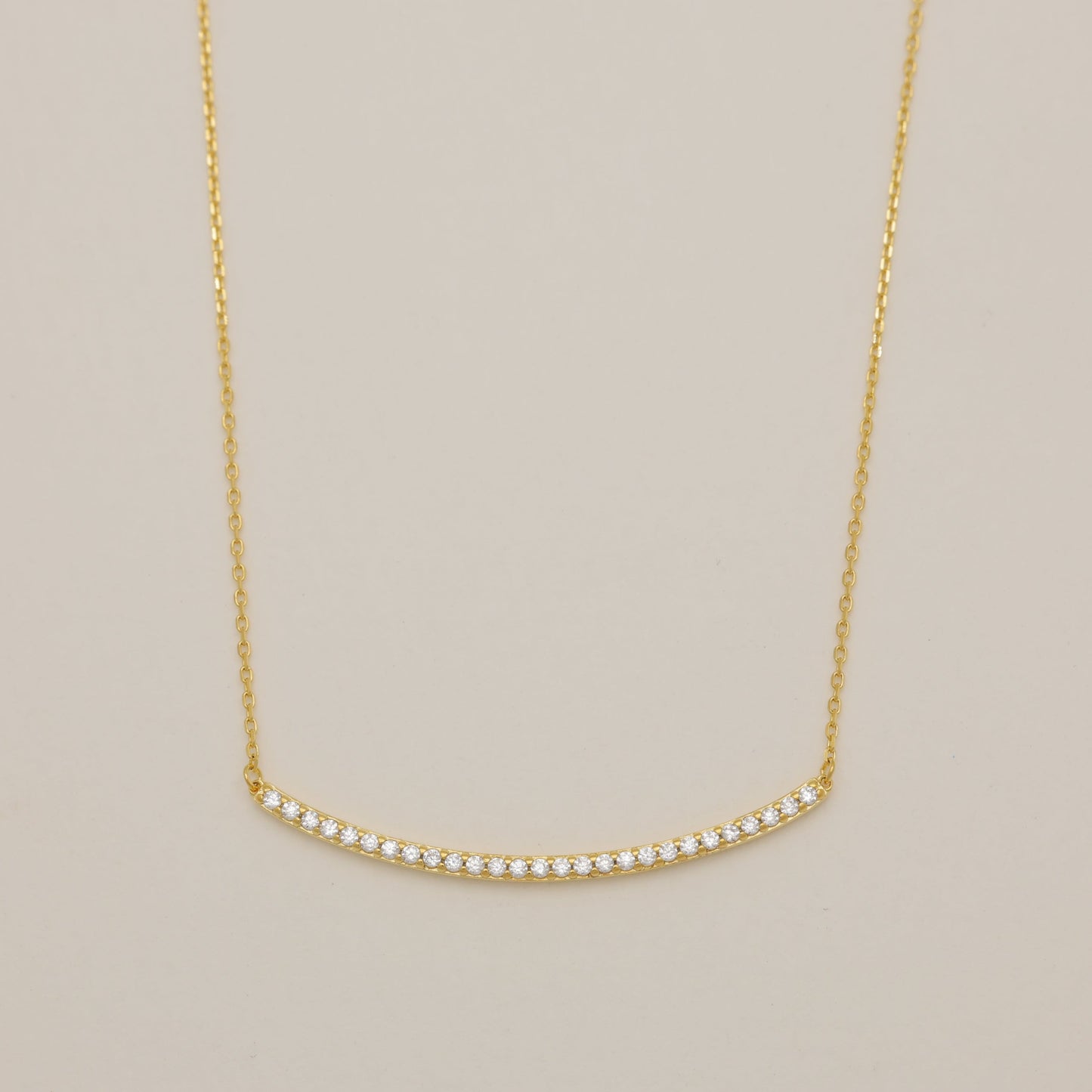 Gold necklace on a beige background