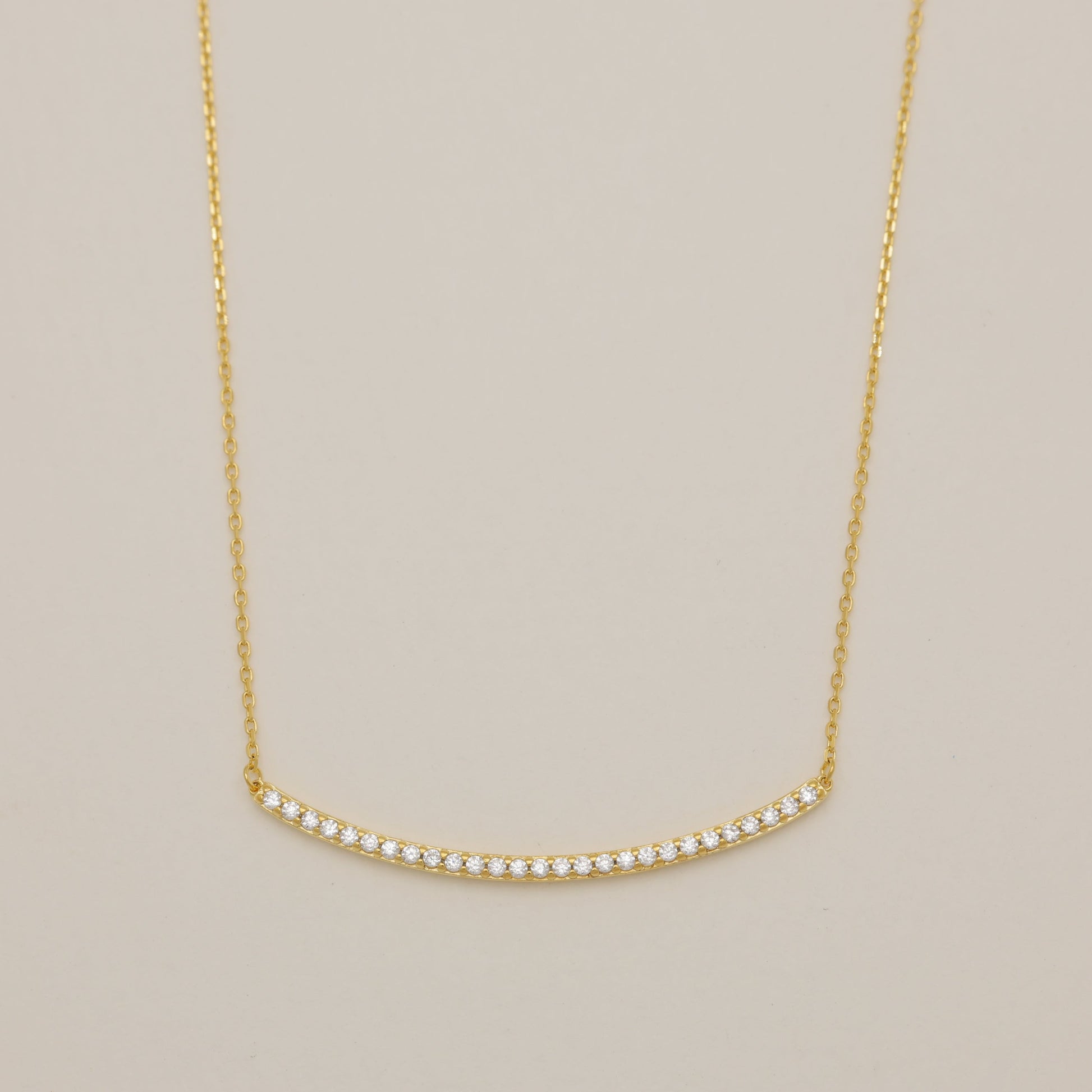 Gold necklace on a beige background