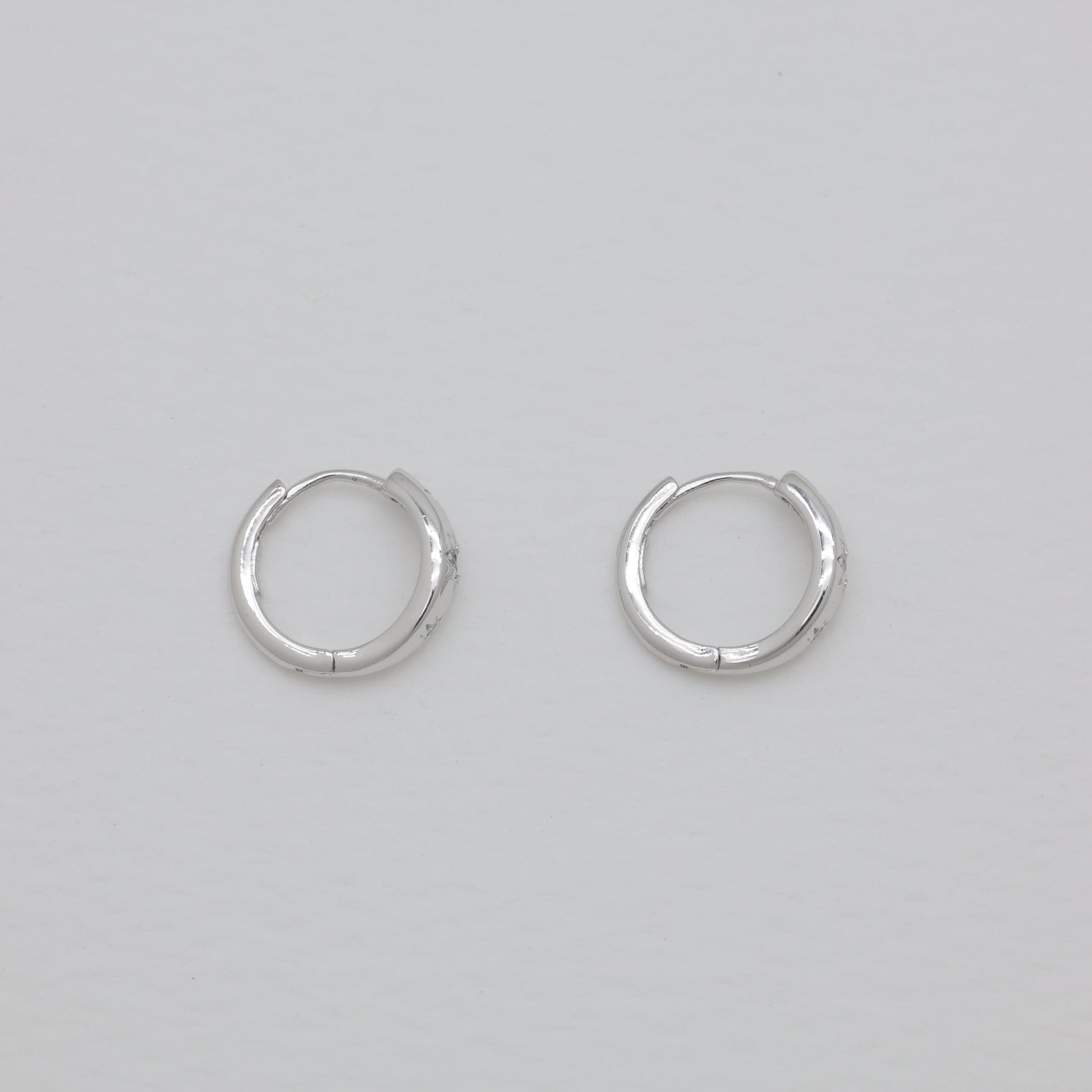 Pair of silver hoop earrings on a light gray background