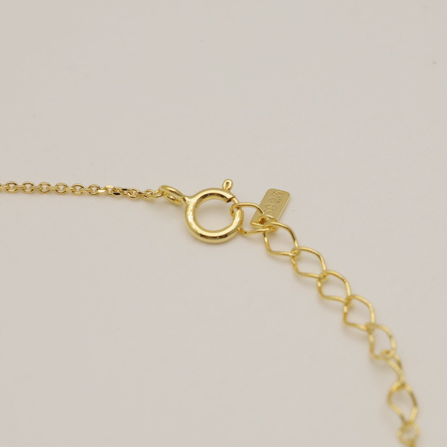 Gold bracelet on a light beige background