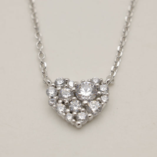 Heart-shaped diamond necklace on a light gray background