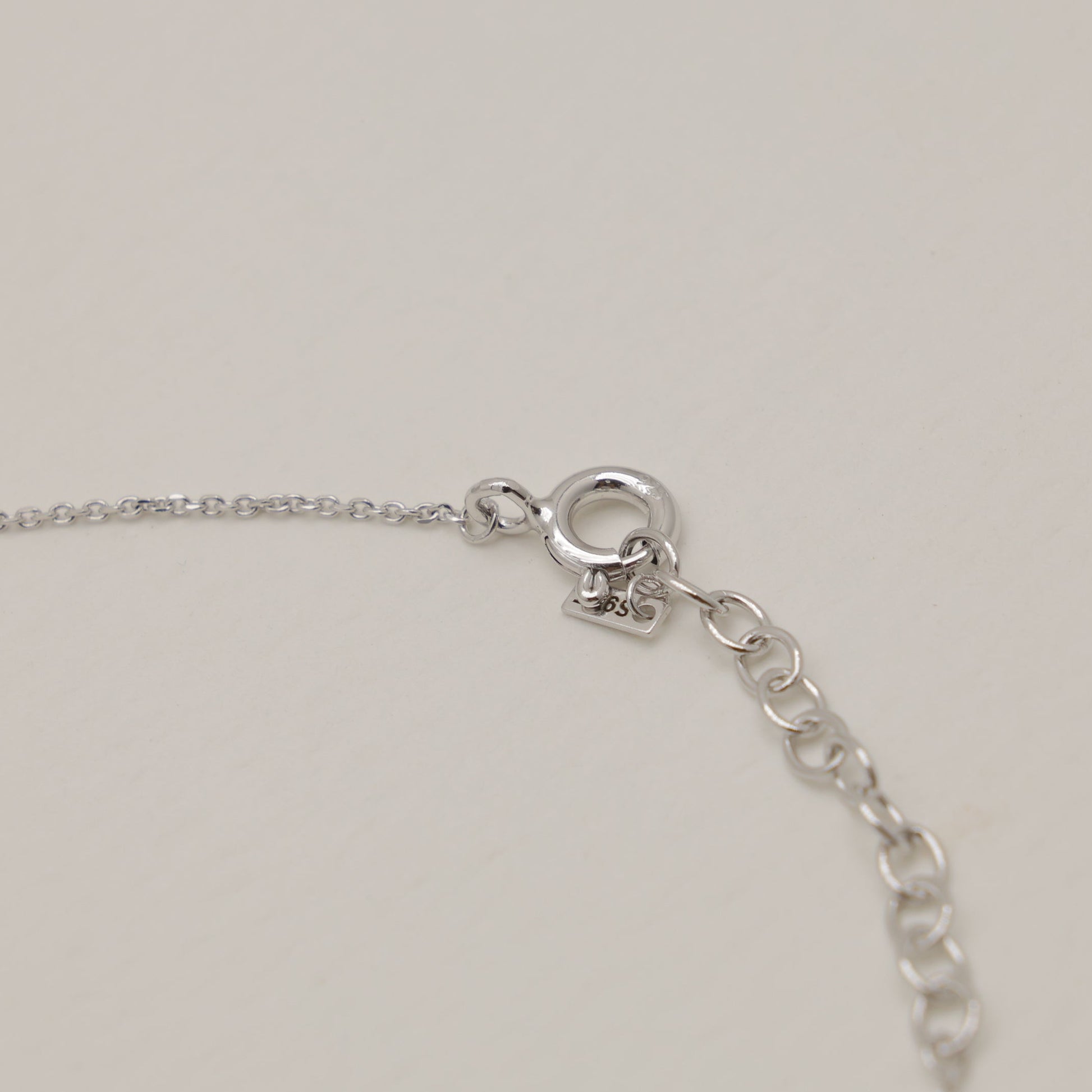 Close-up of a silver bracelet on a light gray background
