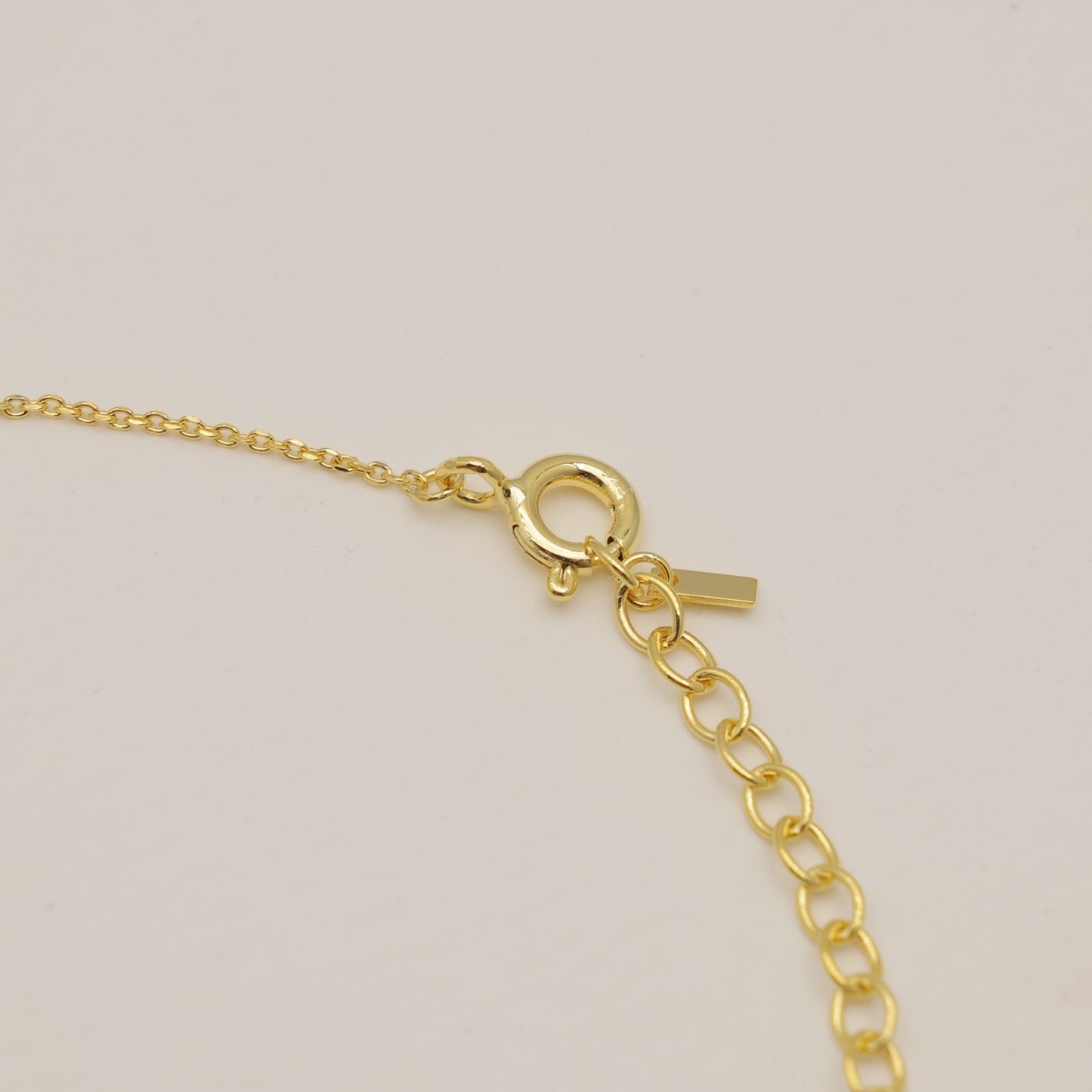 Gold bracelet on a beige background