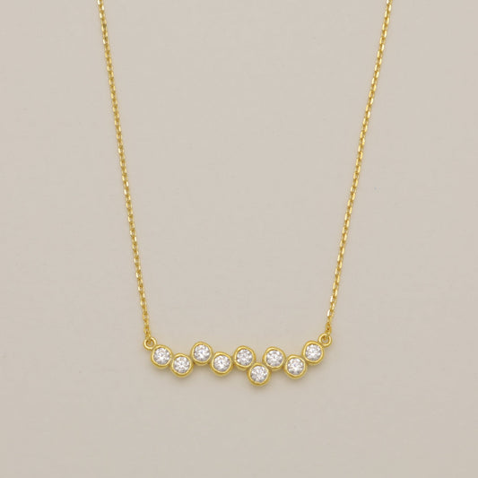 Gold necklace with small diamonds on a beige background