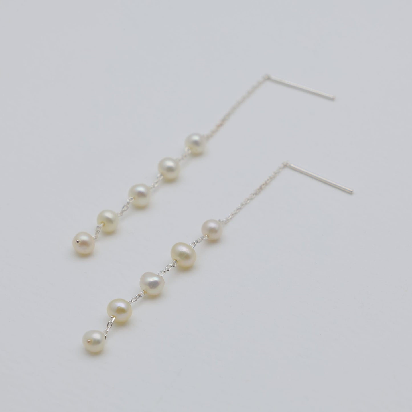 Pearl earrings on a light gray background