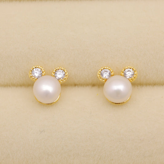 Pearl earrings with gold accents on a beige background