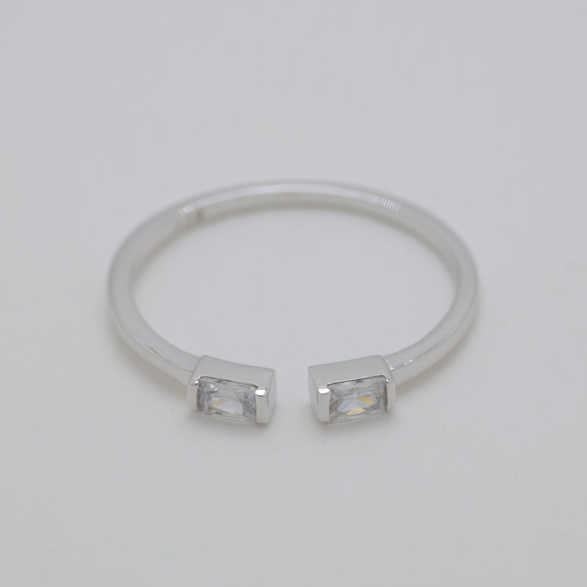 Silver ring with two small stones on a light gray background