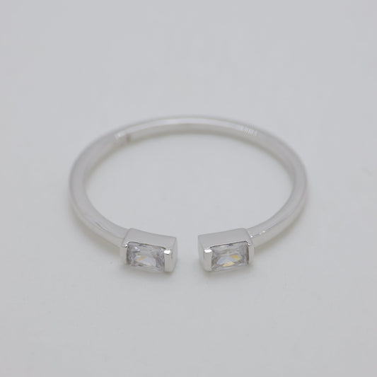 Silver ring with two small stones on a light gray background