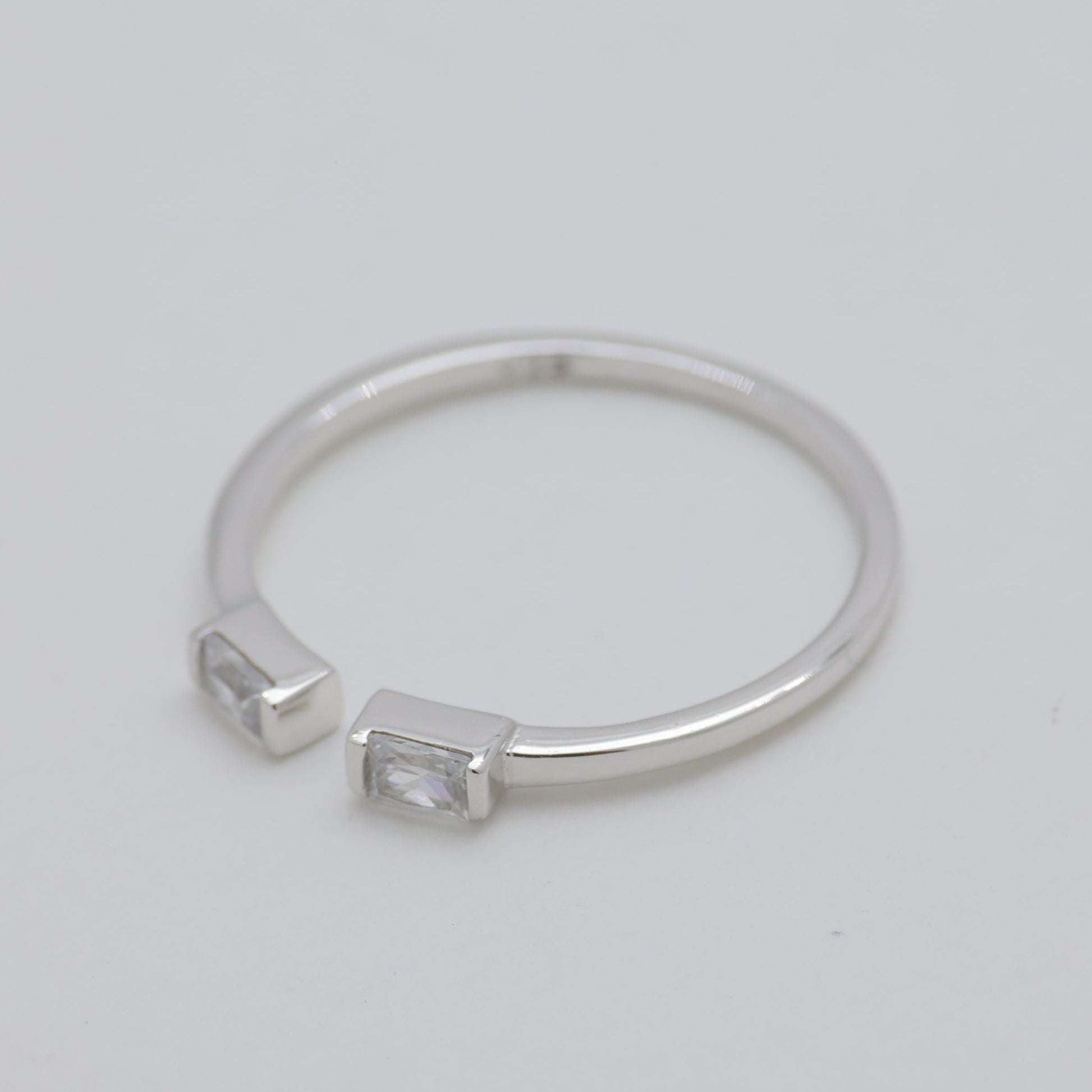 Silver ring with engraved design on a light gray background