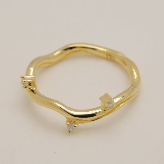 Gold ring with small diamonds on a beige background