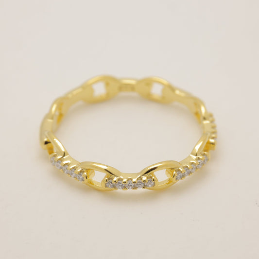 Gold ring with diamond accents on a beige background