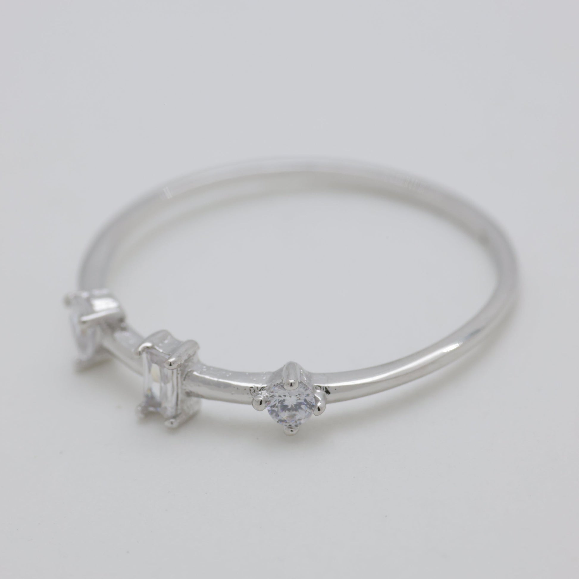 Silver bracelet with star and heart charms on a light gray background
