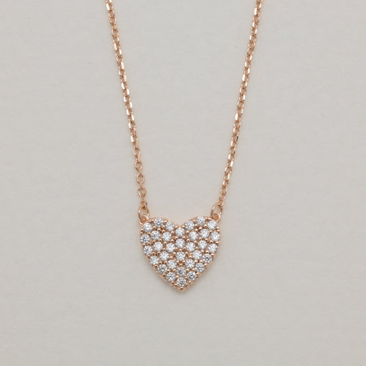 Heart-shaped diamond necklace on a light gray background