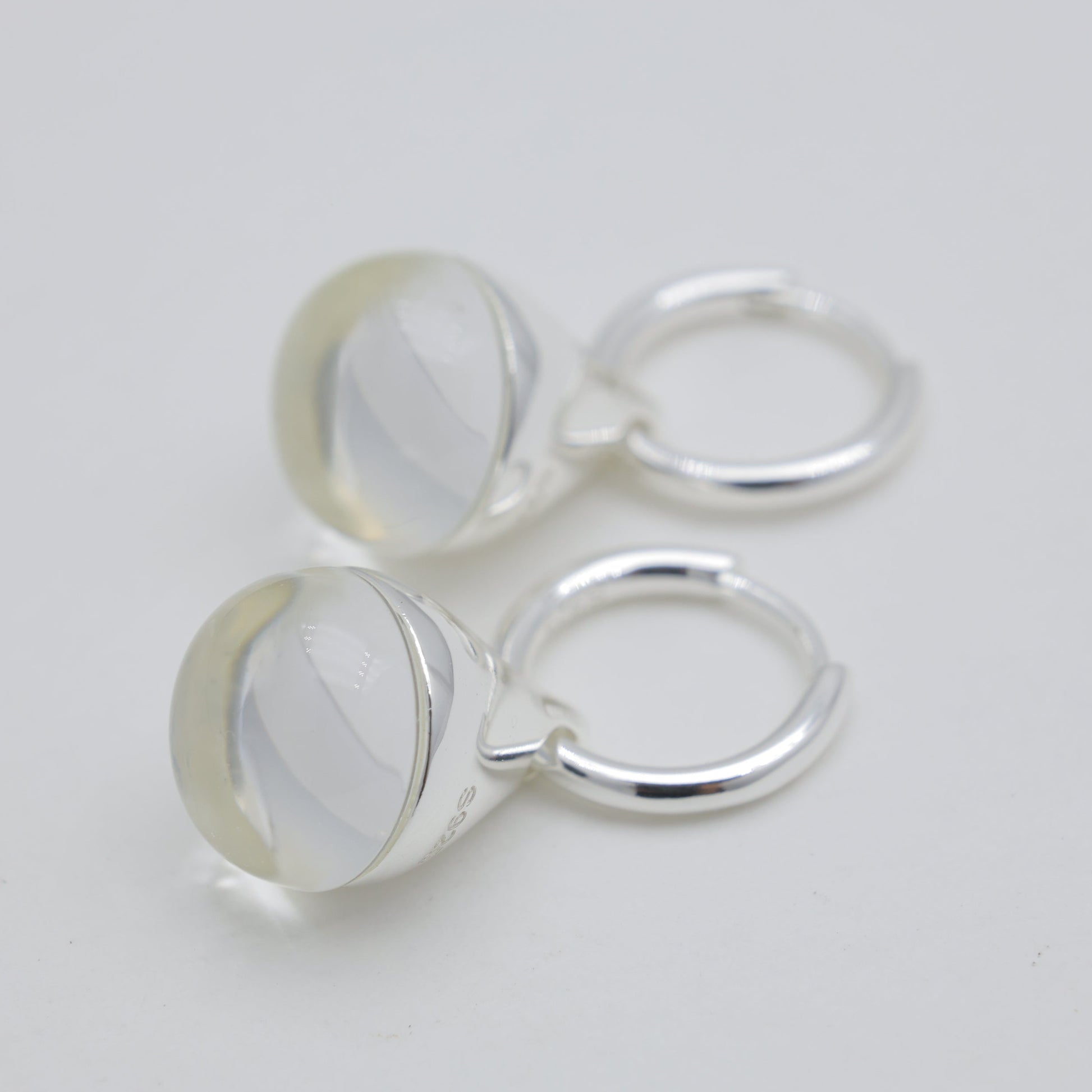 Three silver hoop earrings on a light gray background