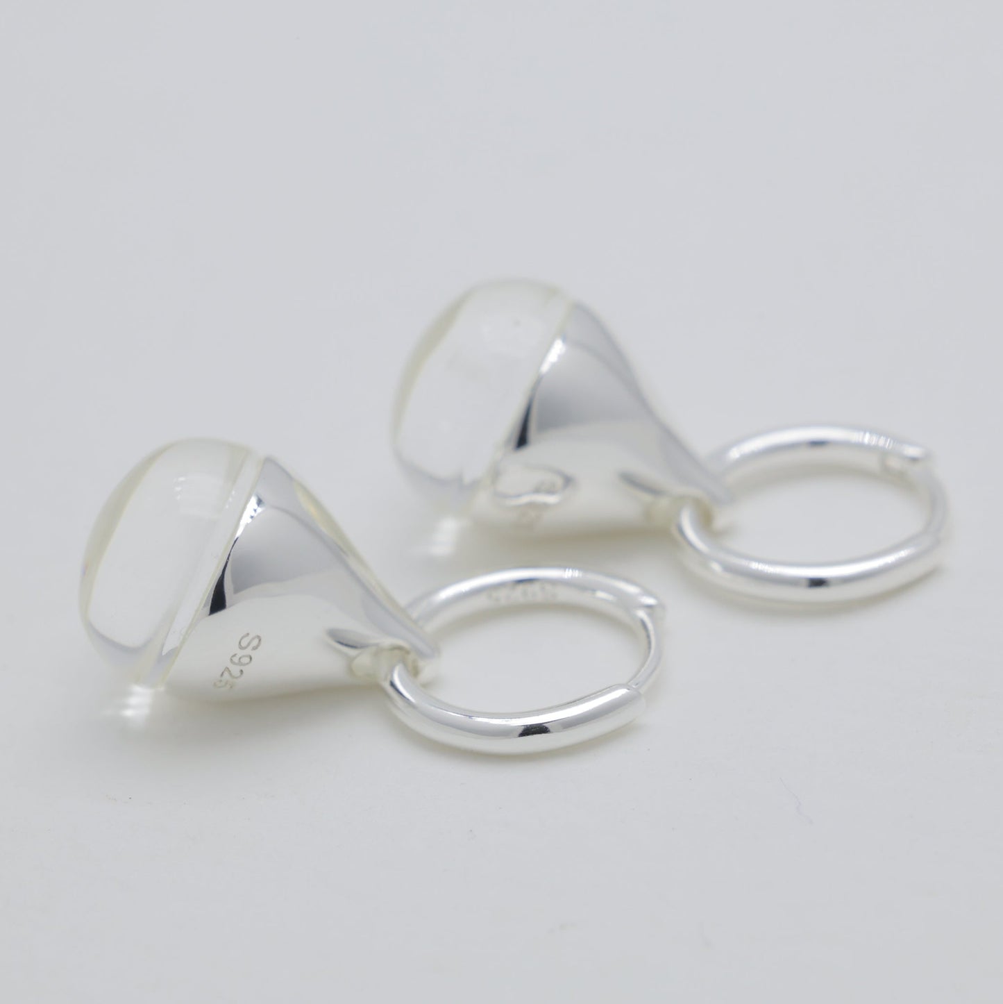 Pair of silver earrings on a light gray background