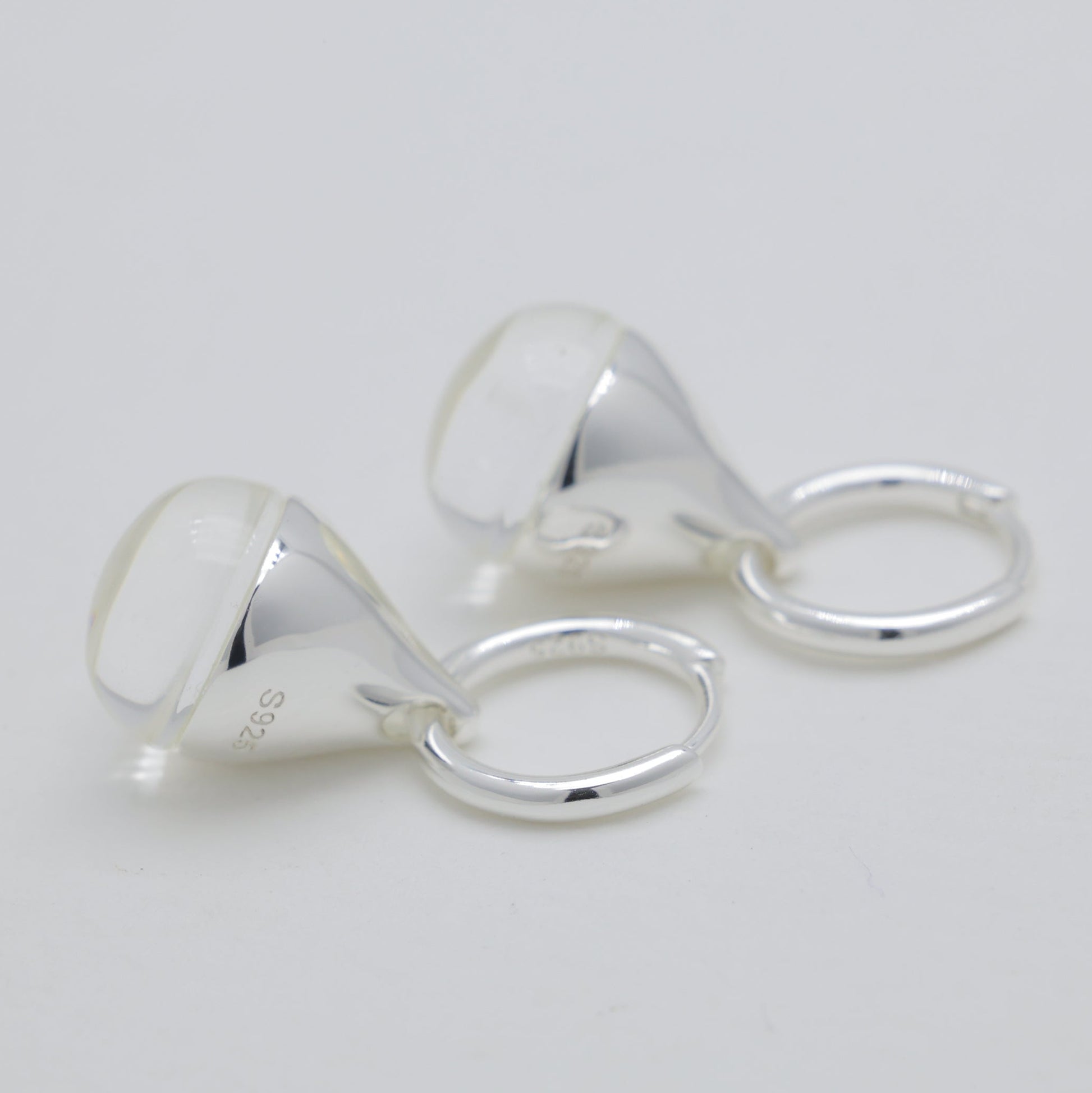 Pair of silver earrings on a light gray background