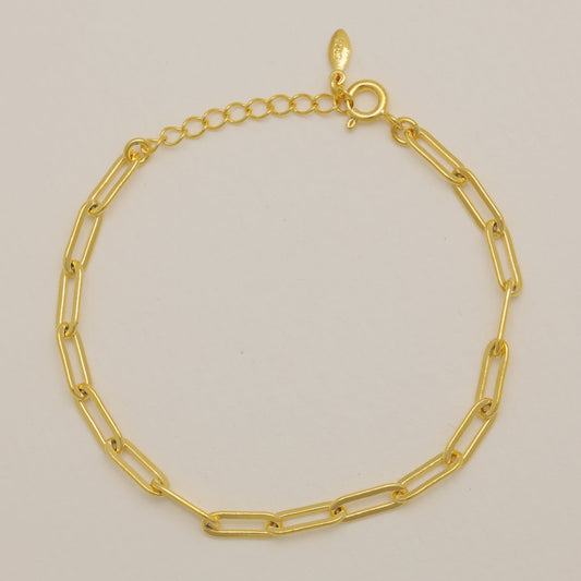 Gold chain bracelet on a beige background