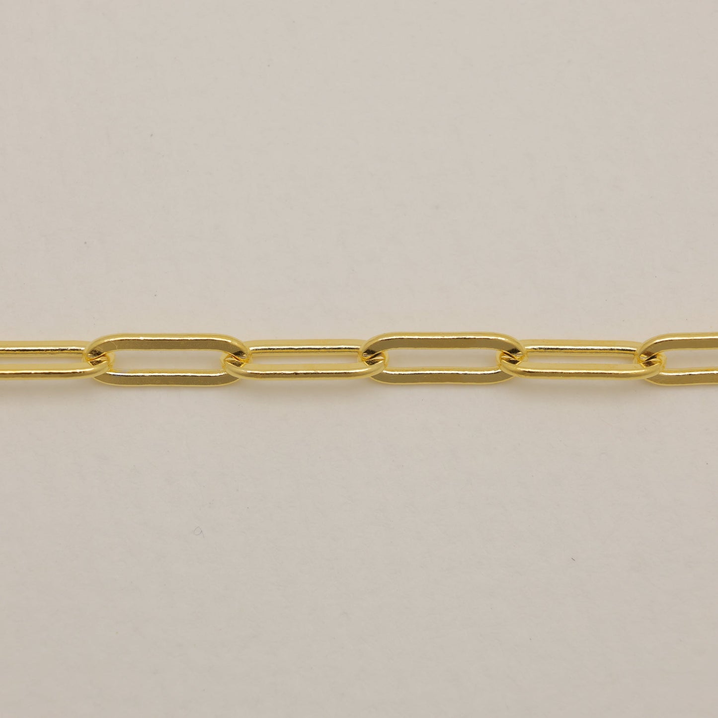 Gold chain on a beige background