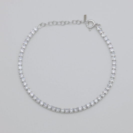 Silver bracelet with clear stones on a light gray background