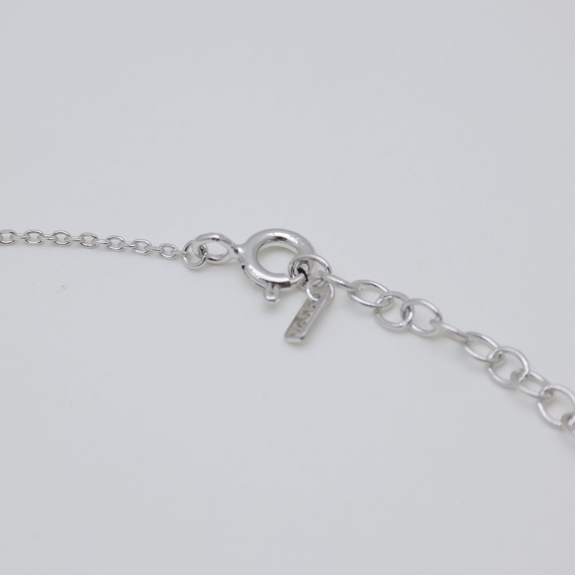 Close-up of a silver bracelet on a light gray background
