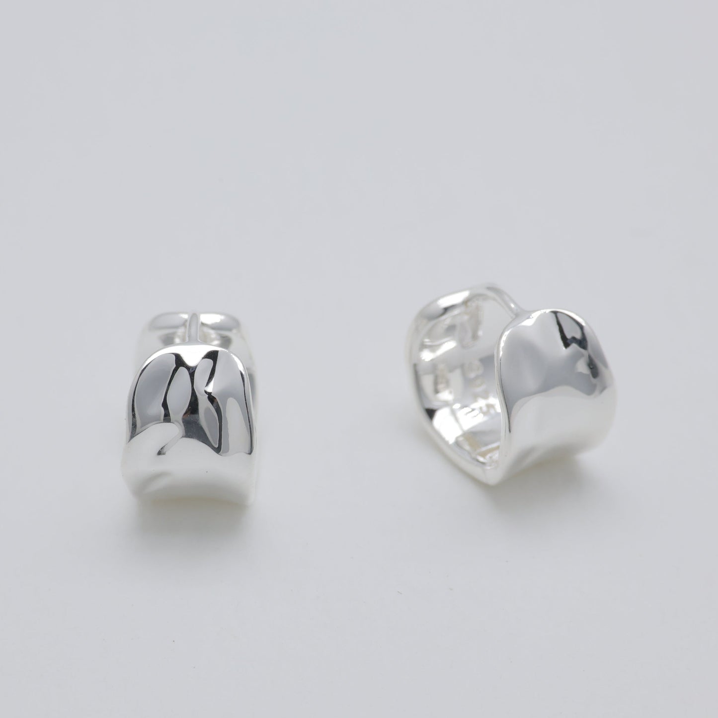 Pair of silver earrings on a light gray background