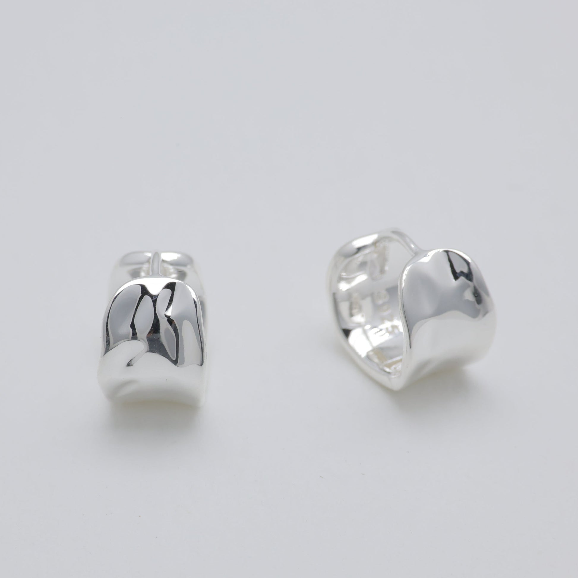 Pair of silver earrings on a light gray background