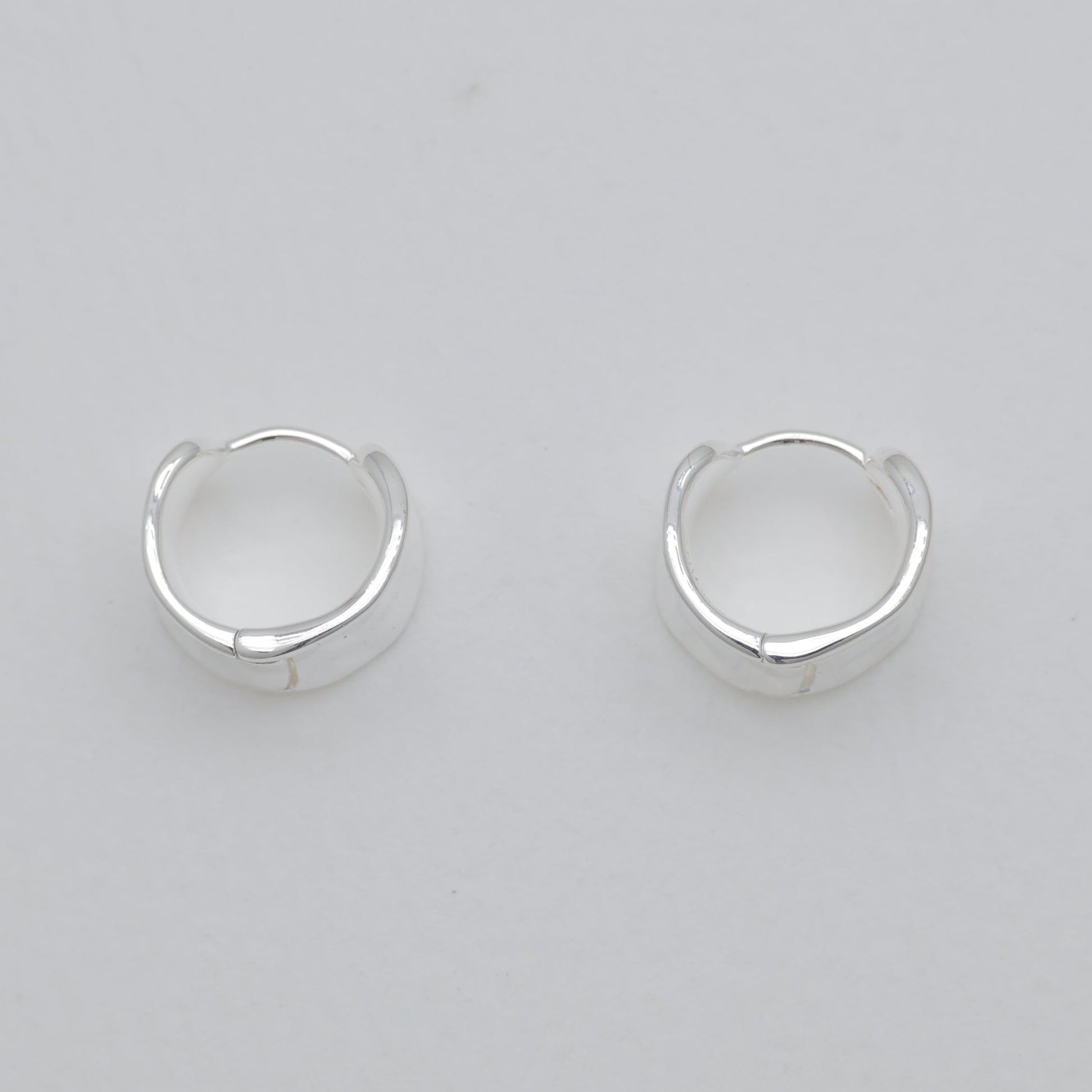 Pair of silver hoop earrings on a light gray background