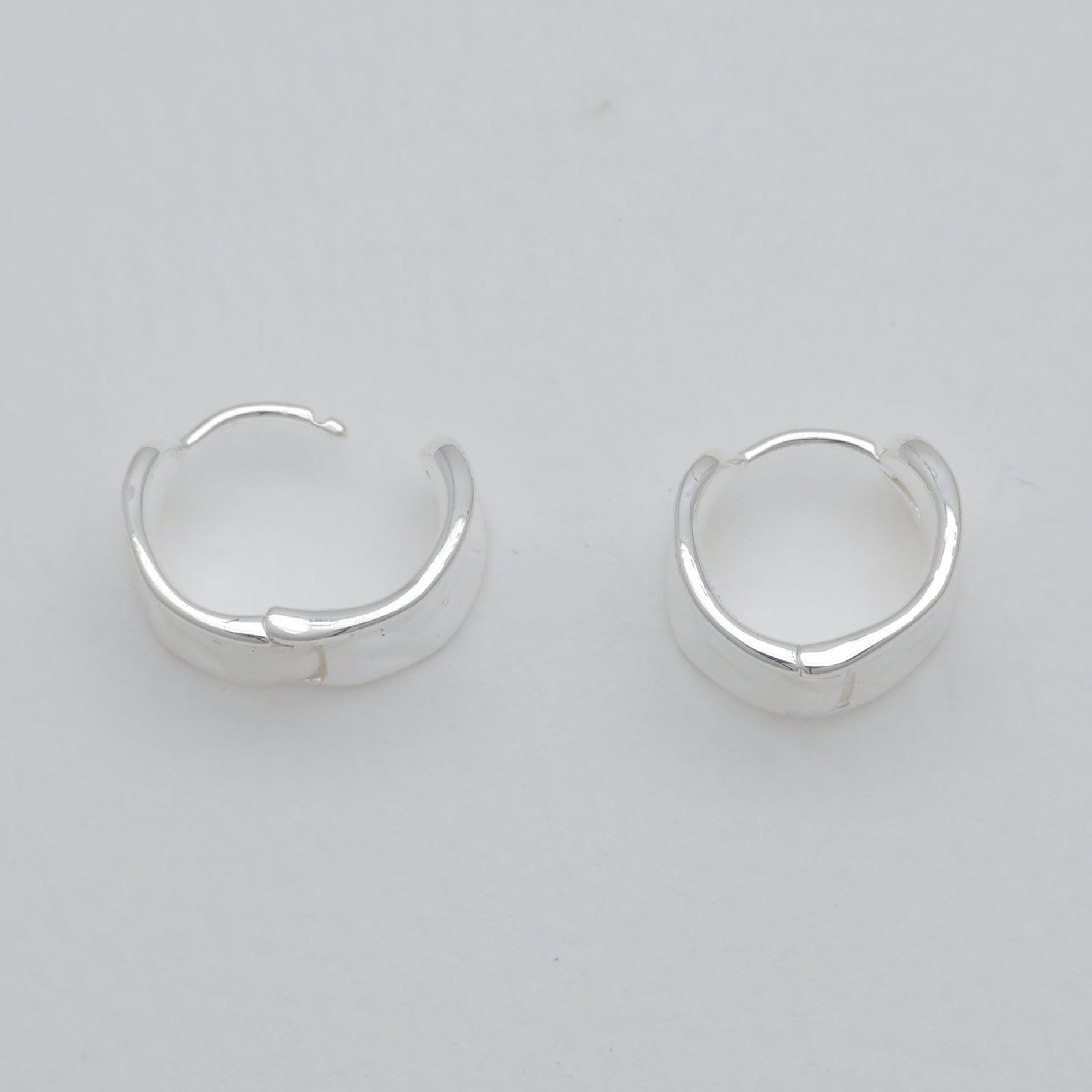 Pair of silver hoop earrings on a light gray background