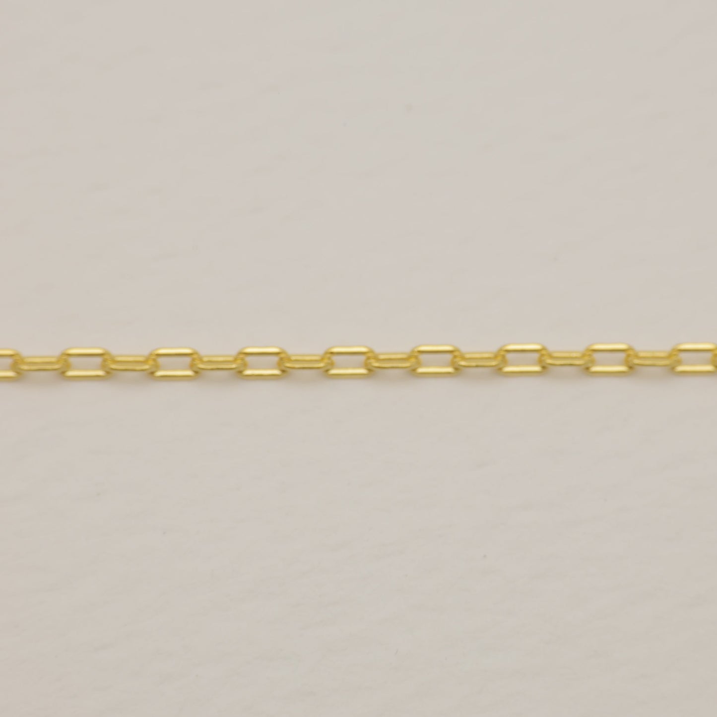 Gold chain on a light gray background