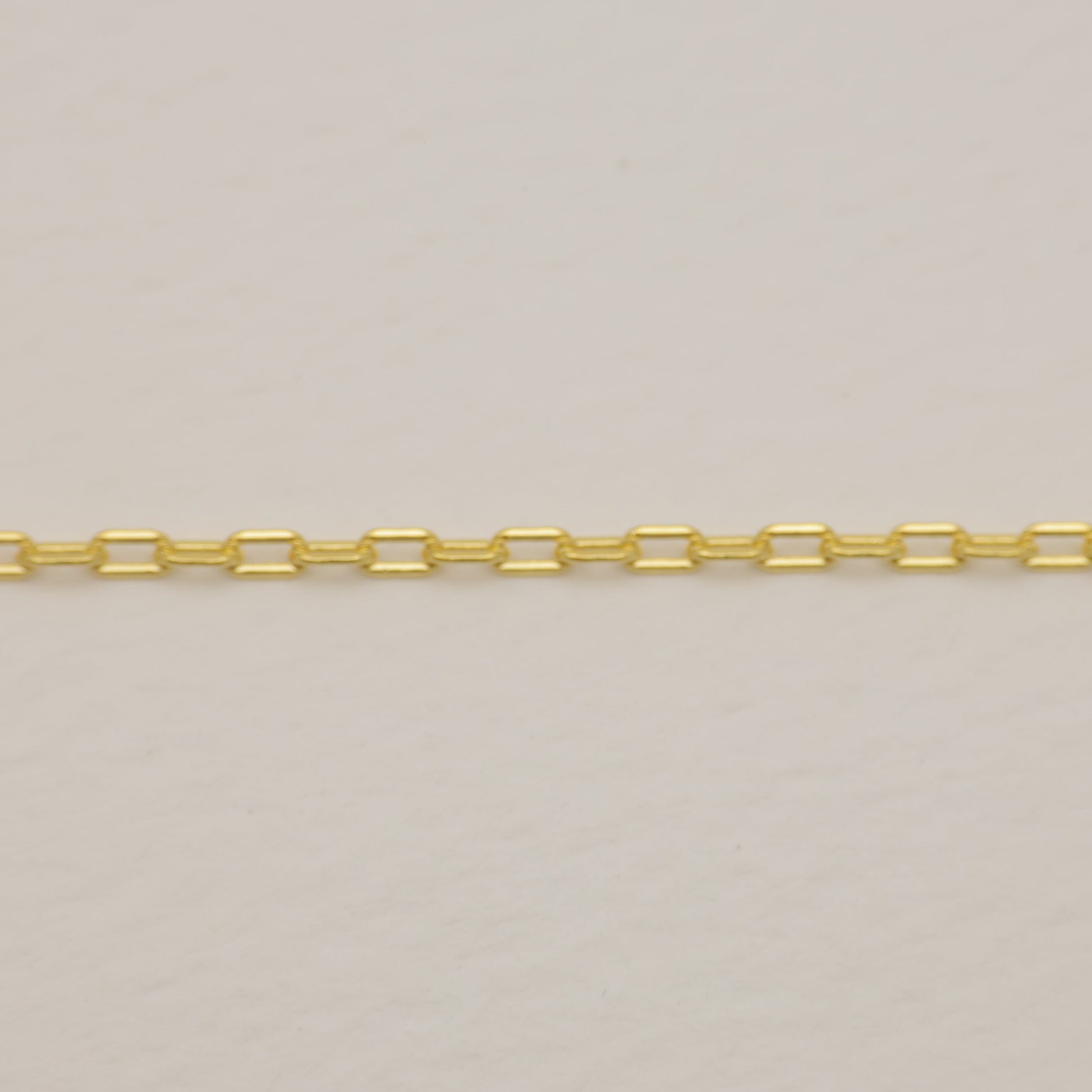 Gold chain on a light gray background