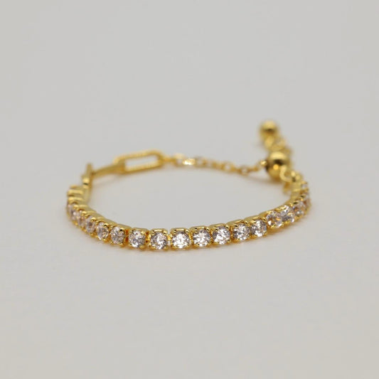 Gold vermeil adjustable pavé ring featuring a row of cubic zirconia stones, open back for easy sizing, styled on a neutral background.
