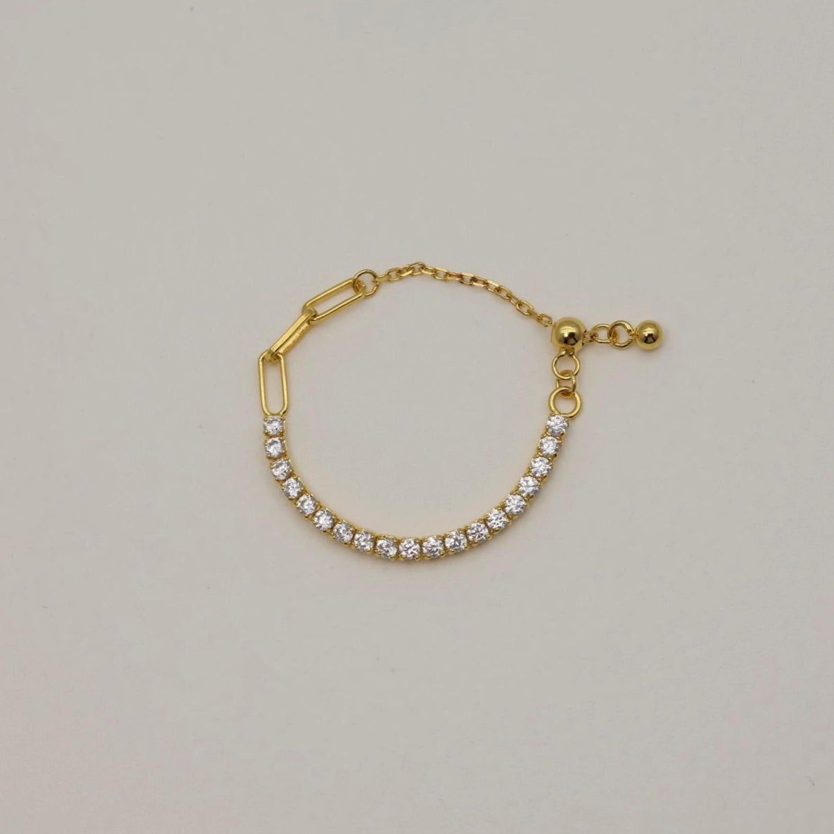 Gold vermeil adjustable pavé ring featuring a row of cubic zirconia stones, open back for easy sizing, styled on a neutral background.