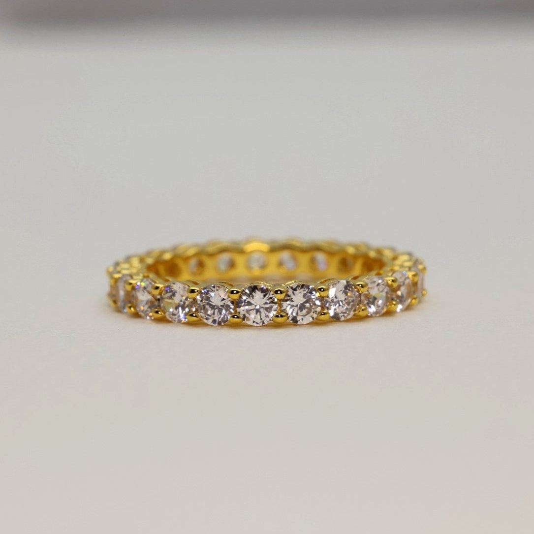 Gold ring with diamonds on a light gray background