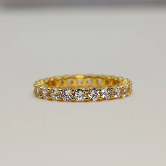 Gold ring with diamonds on a light gray background
