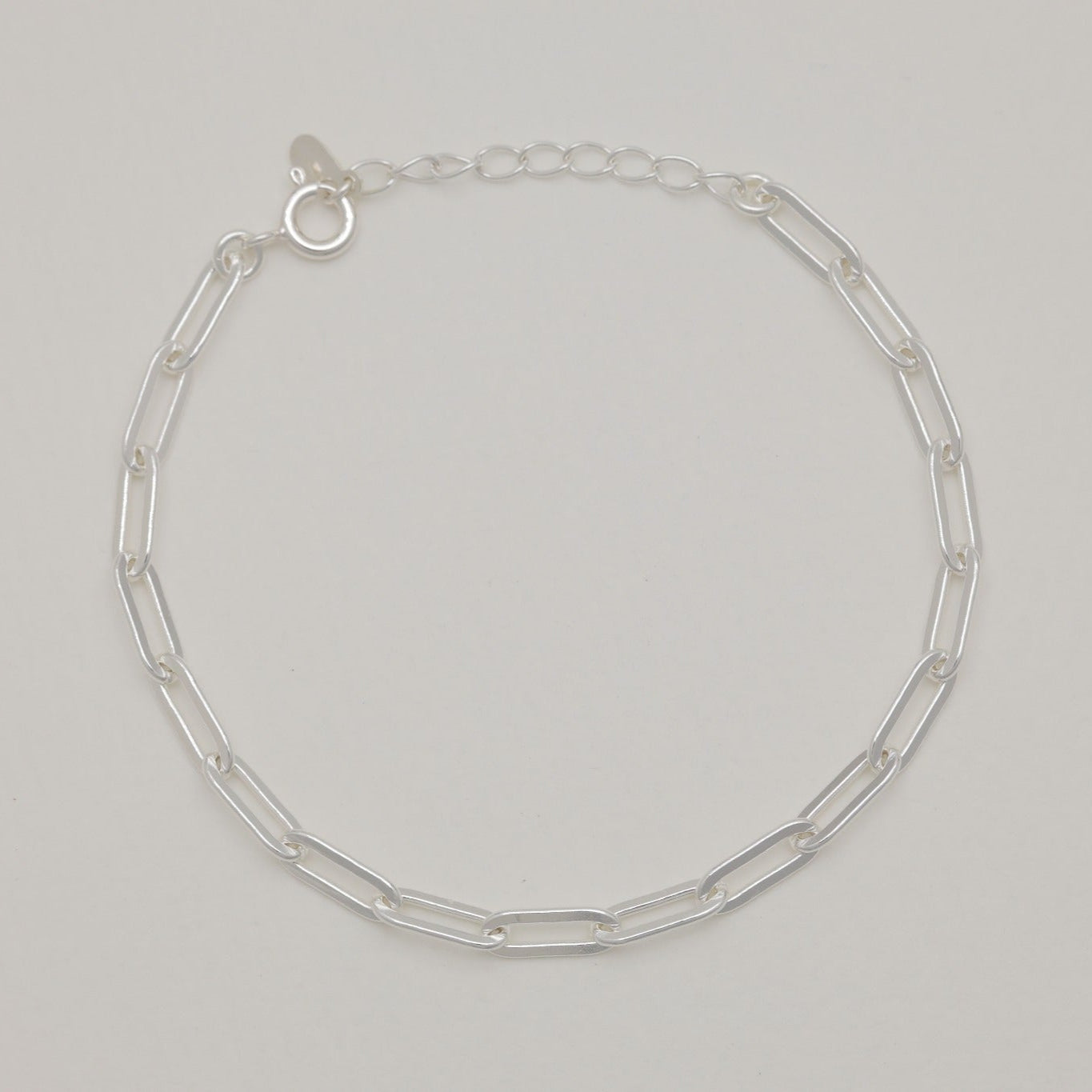 Maïa Chain Bracelet in sterling silver laid flat on soft neutral background