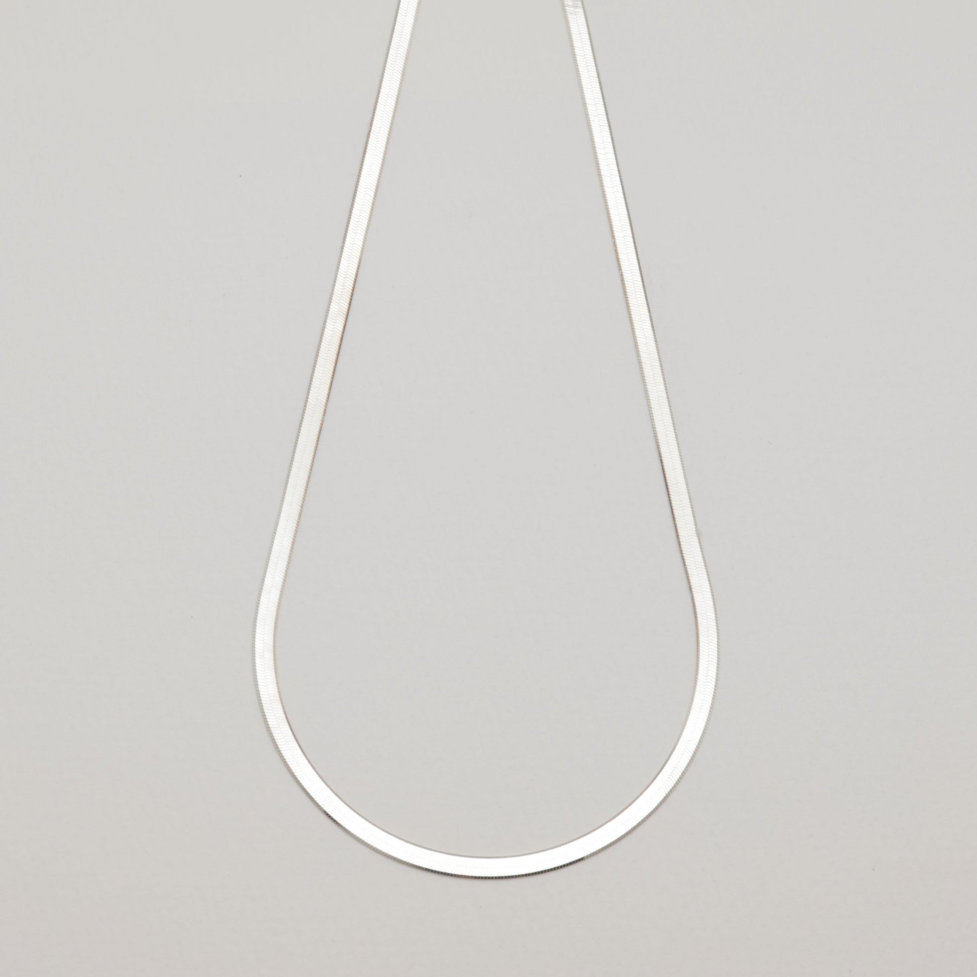 Full view of the Margaux Chain Necklace in sterling silver laid flat on neutral background