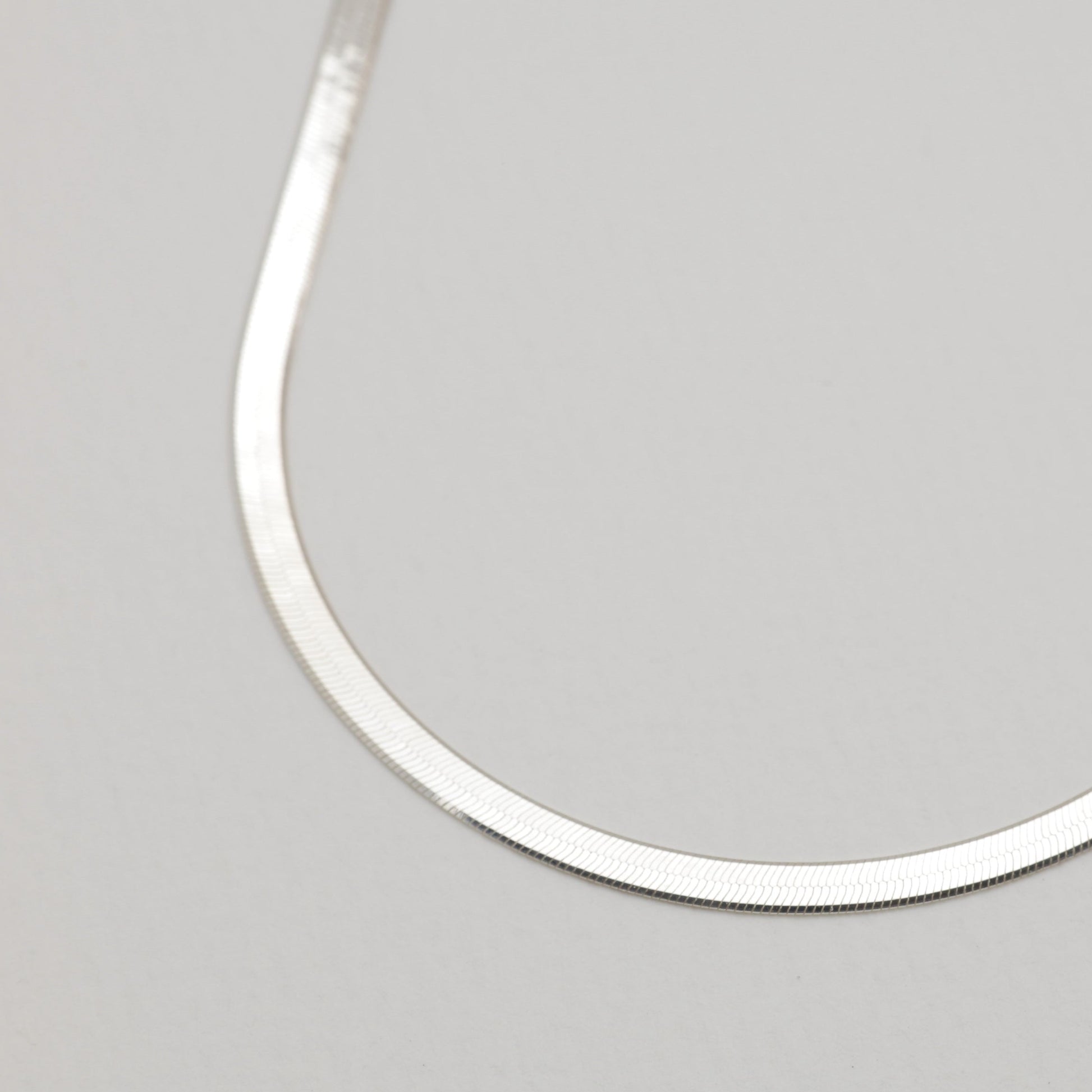 Close-up of the herringbone chain texture of the Margaux Necklace