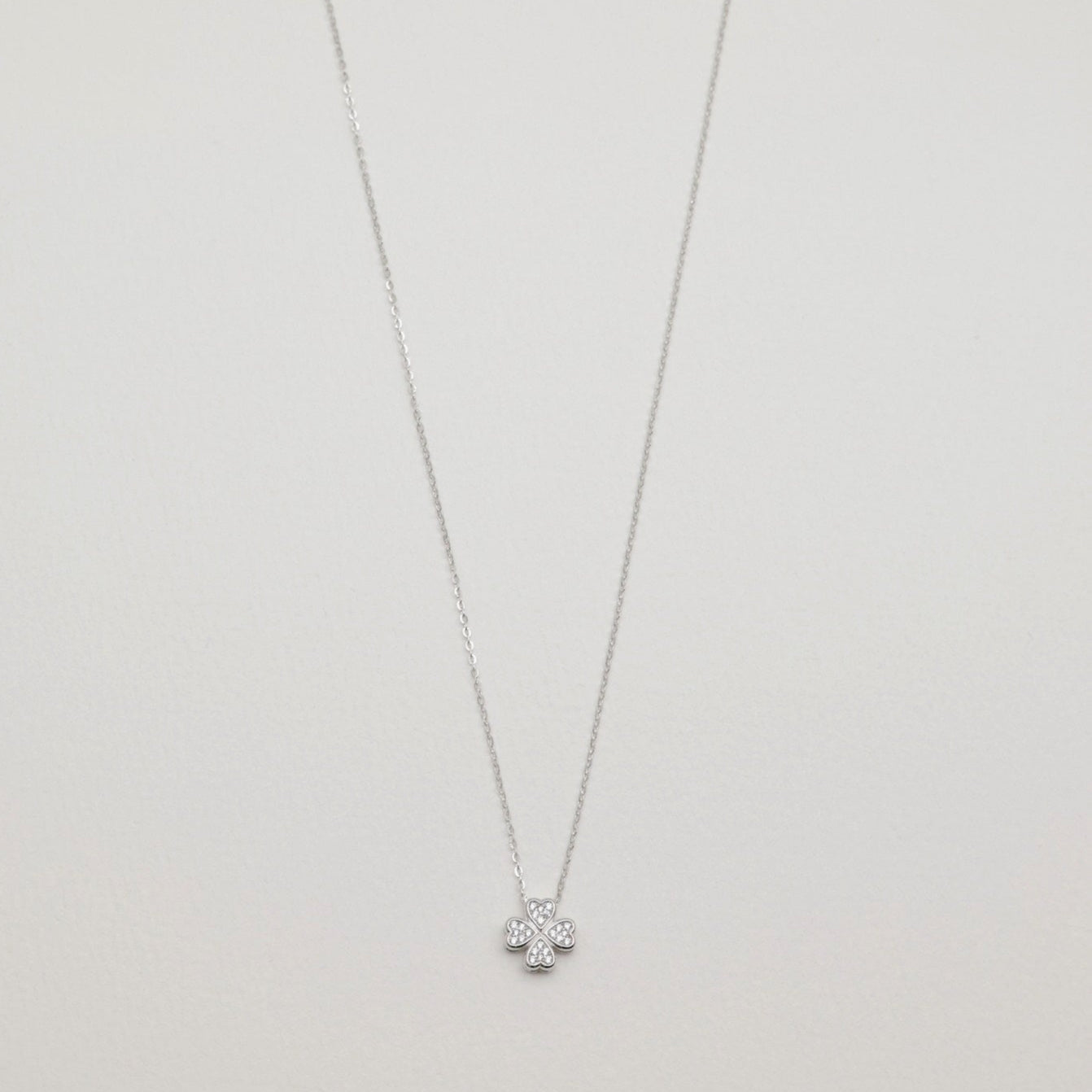 Full view of the Fleur Necklace in sterling silver with cubic zirconia floral pendant on a white background