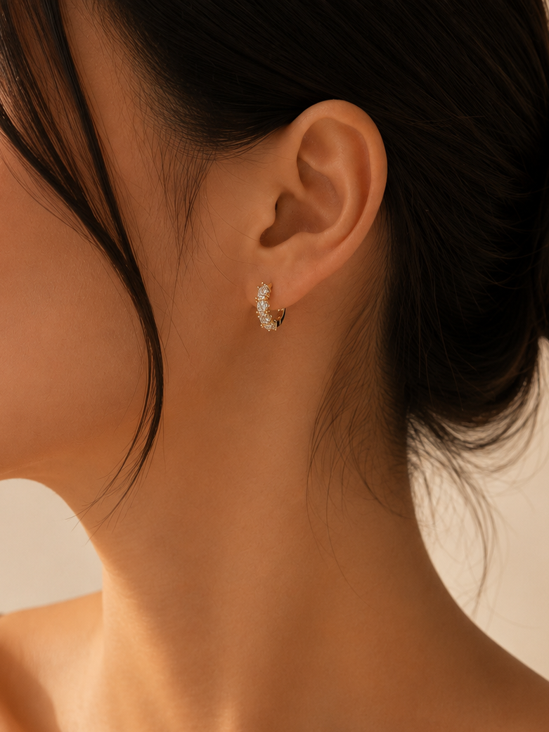Close-up of a woman wearing a delicate earring with a neutral background
