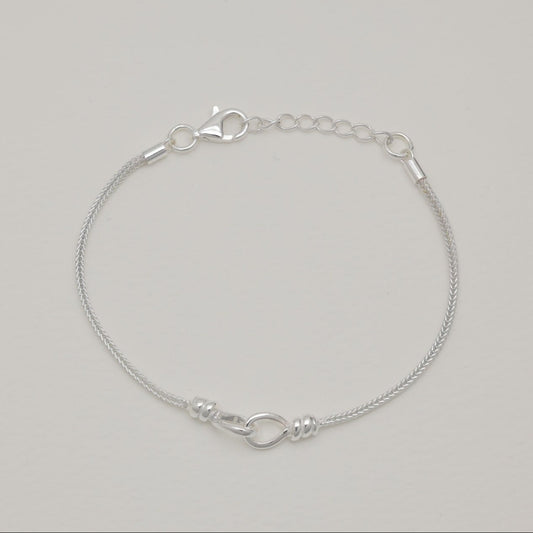 Sterling silver rope chain bracelet with clasp and adjustable links on light background.