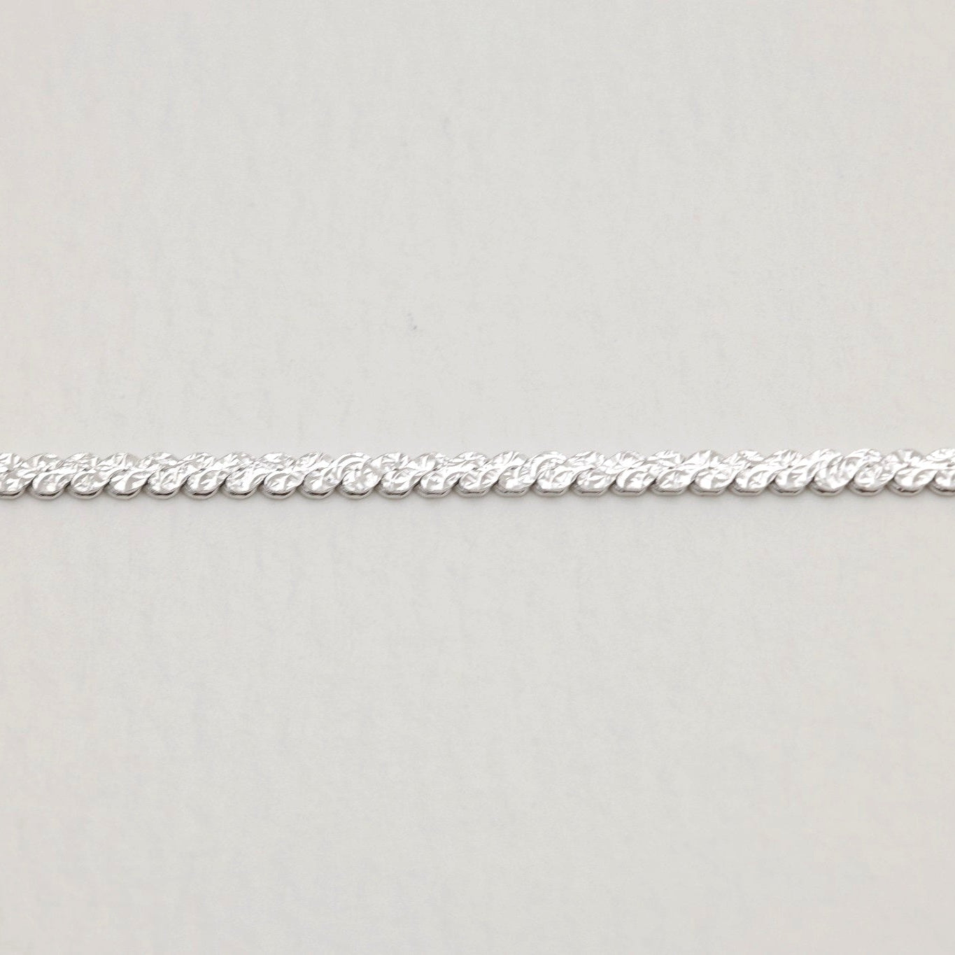 Close-up of the textured twisted side of the Cléa Chain Necklace showing its intricate detailing.


