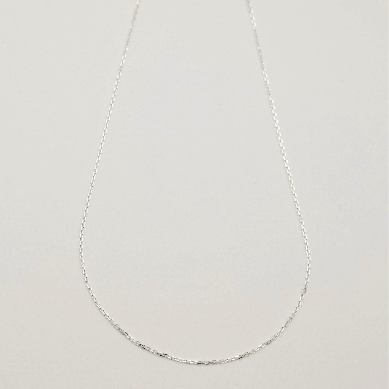 Subtle shine of the chain links capturing light against a soft surface.