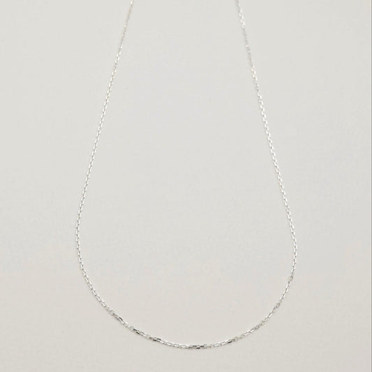 Subtle shine of the chain links capturing light against a soft surface.