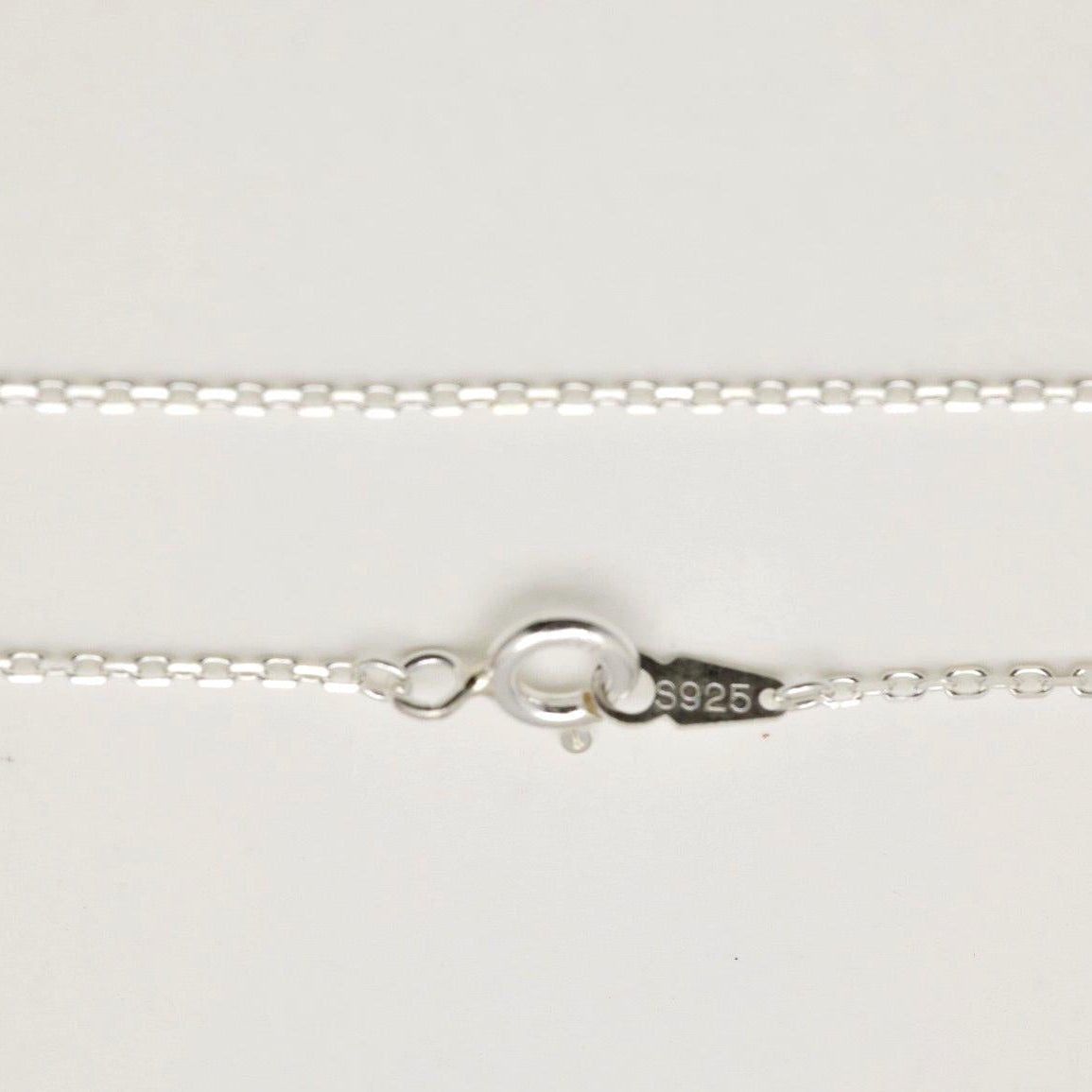 Subtle shine of the chain links capturing light against a soft surface.